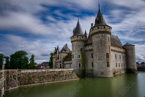 Castle of Sully-sur-Loire, Loire region, France. Snap of 30 June 2017 at 18:21. Captured at the entrance of the castle park. White clouds moving on blue sky. Towers well visible in the image.