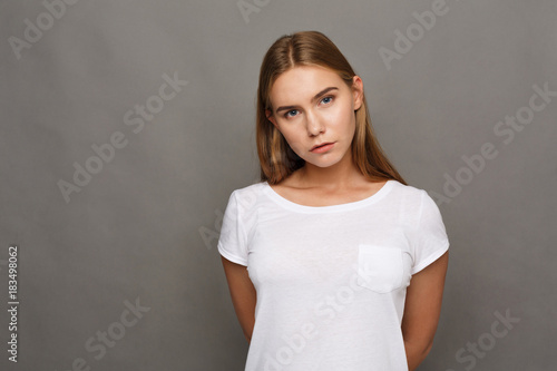 Young woman studio headshot portrait on gray background © Prostock-studio