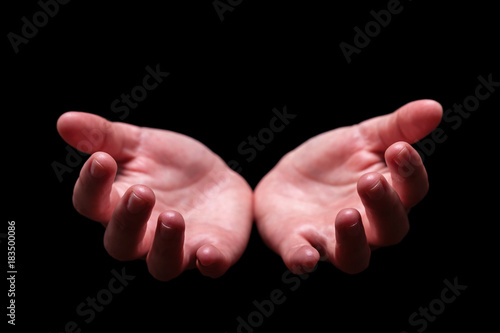 Woman hands cupped in a welcoming, accepting, offering, giving, begging, receiving gesture. Also for praying, prayer, welcome, accept, give, receive, protect, concept. Black background, front view