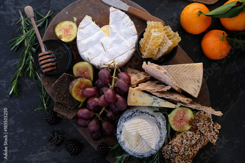 Photos Seasonal cheese platter, with a variety of cheeses, fruit, honey, crackers and sprigs of rosemary
