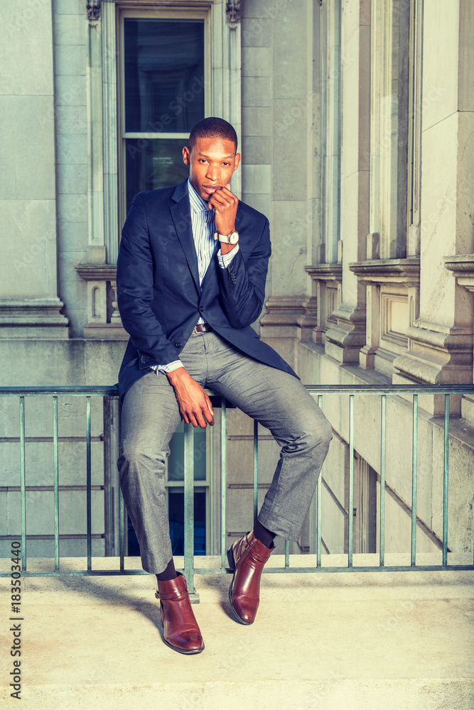 bulge atmosphere slogan Dressing in black blazer, gray pants, brown leather shoes, wristwatch, African  American businessman sitting on railing in vintage style office building,  fist touching chin, thinking. . Stock Photo | Adobe Stock