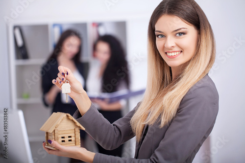 Meeting with agent in office, buying renting apartment or house, buyers of real estate ready to conclude a deal, two women shaking hands with realtor after signing documents for realty purchase .