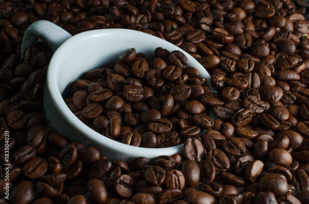 White Cup drowned in coffee beans White Cup drowned in coffee beans
