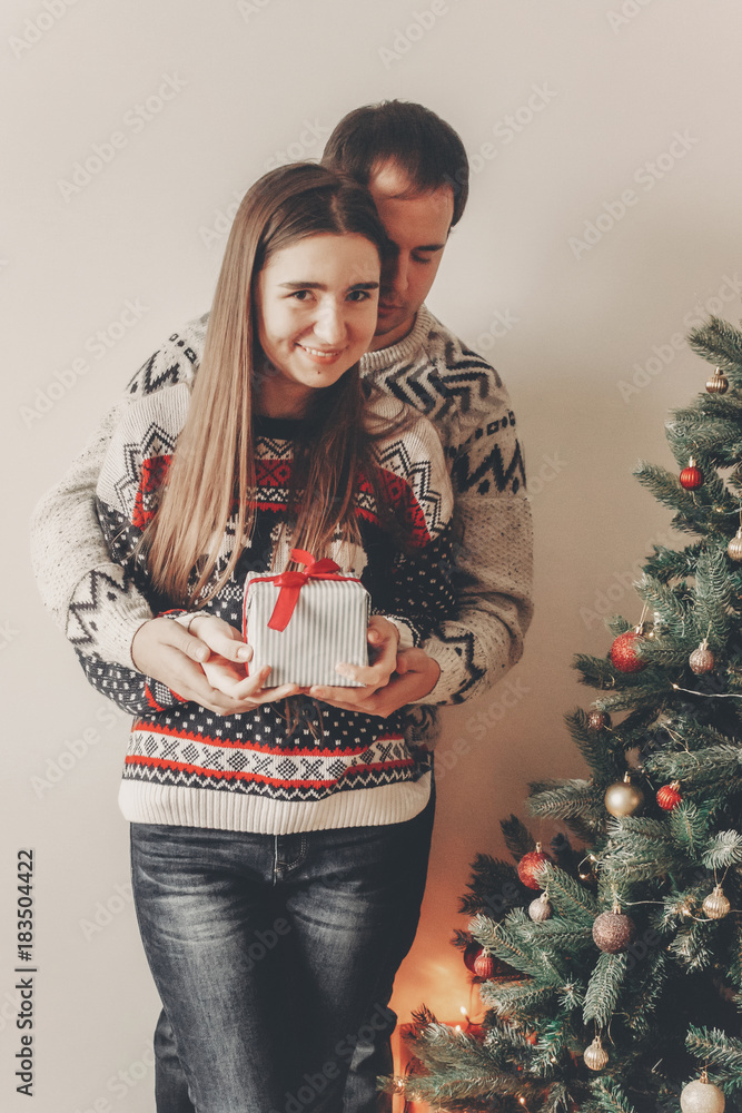 happy family in stylish sweaters exchanging gifts in festive room with christmas tree and lights. emotional moments. merry christmas and happy new year concept. happy holidays happy family in stylish sweaters exchanging gifts in festive room with christmas tree and lights. emotional moments. merry christmas and happy new year concept. happy holidays