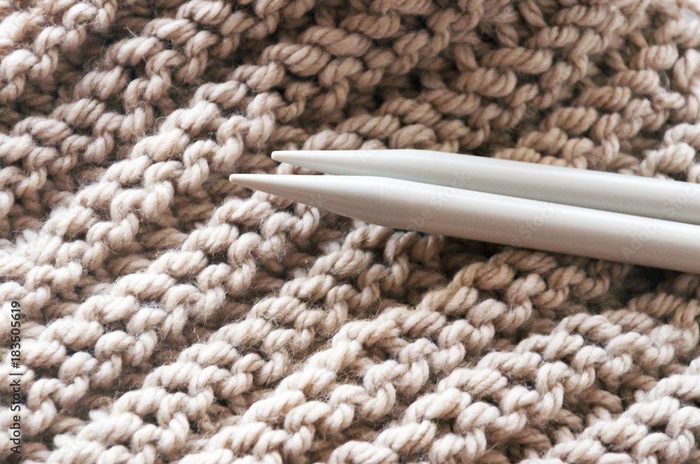 A knitted scarf with a thick thread on thick beige knitting
