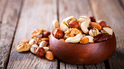 Nuts Mixed in a wooden plate.Assortment, Walnuts,Pecan,Almonds,Hazelnuts,Cashews,Pistachios.Concept of Healthy Eating.Vegetarian.Copy space.selective focus.