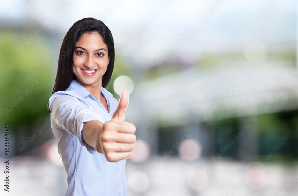 Laughing arabic businesswoman showing thumb
