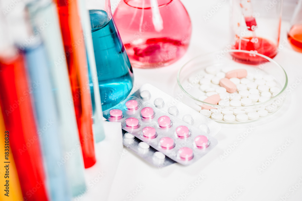 pills and test tubes in laboratory. drug discovery, pharmacology and biotechnology concept. science and medical research background.