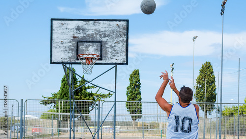 Basketball player shooting in a playground © Gabriele Maltinti