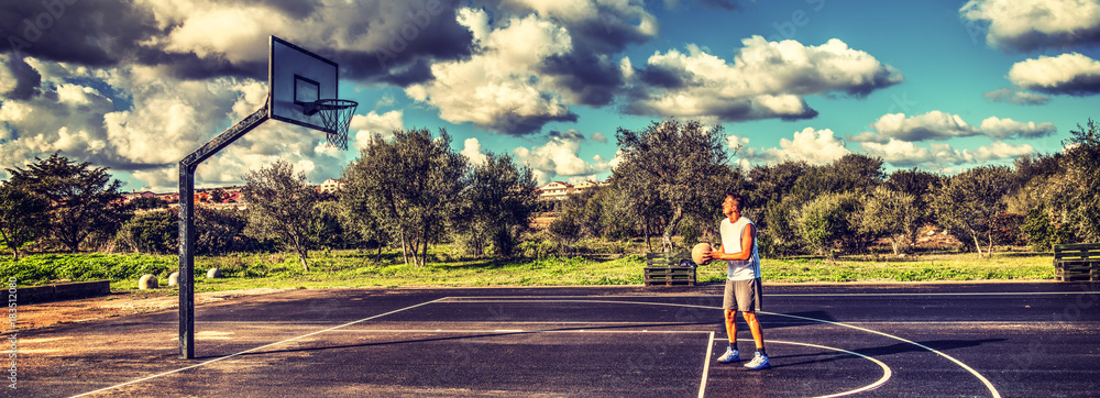Obraz premium Basketball player practicing free throws in a playground