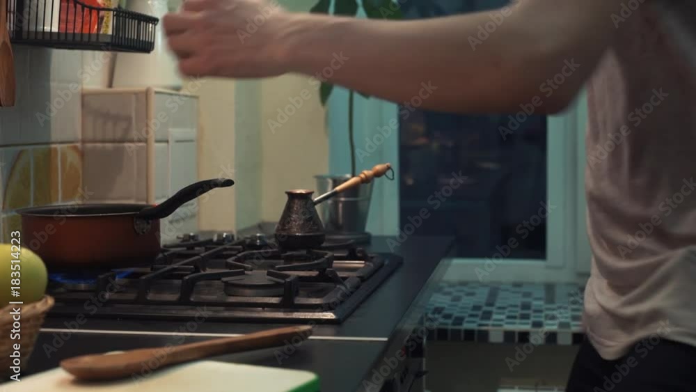 Funny man cooking meal dancing in front of stove at kitchen Funny man cooking meal dancing in front of stove at kitchen