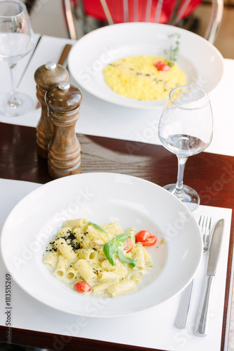 Rigatoni pasta with cheese and cherry tomatoes on italian restaurant.