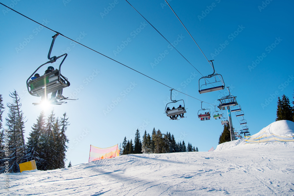 Obraz premium Low angle shot of a ski-lift in the mountains on a sunny winter day copyspace people riding top nature extreme activity sport recreation concept ski resort