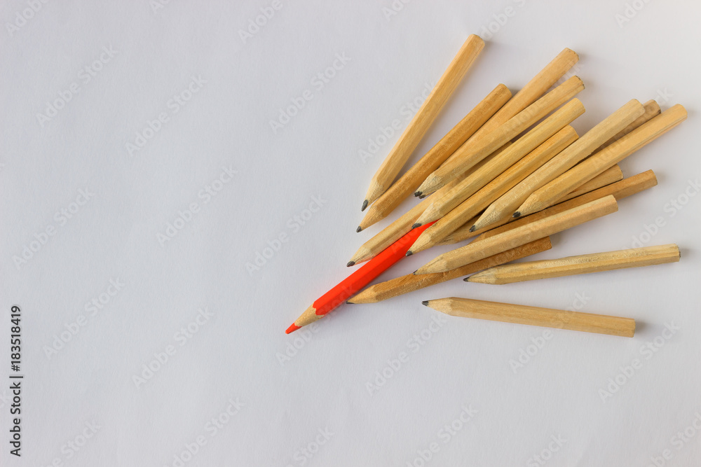 Red pencil standing out from crowd of plenty identical pencils on table. Leadership, uniqueness, independence, initiative, strategy, dissent, think different, business success concept. Red pencil standing out from crowd of plenty identical pencils on table. Leadership, uniqueness, independence, initiative, strategy, dissent, think different, business success concept.