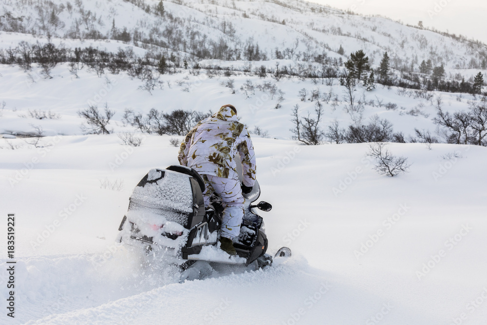 Man driving snowmobile in the snow