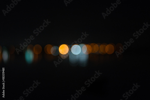 abstract defocused city lights in distance on dark night sky background