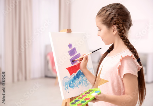 Little girl painting ship at home