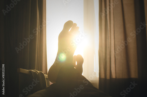 Foto Male legs opposite the sunlight from the window