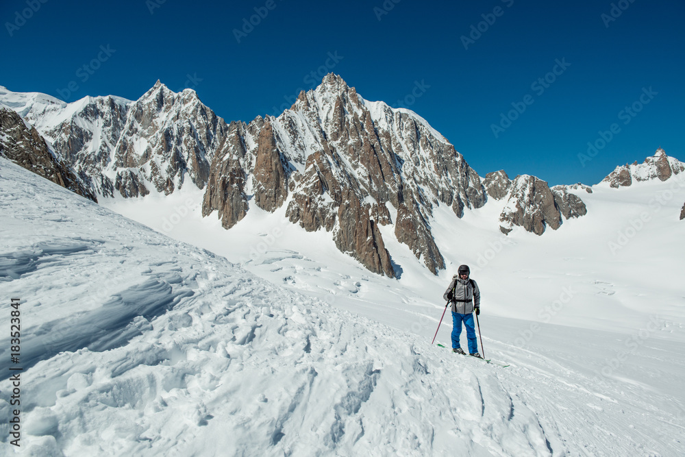 skier man exploring glacier or snowy land walking with snowshoes or alpine ski. Europe Alps Mont Blanc massif mount. Winter sunny day, snow. Wide long shot