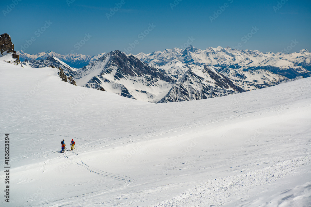 group of people exploring glacier or snowy land walking with alpine ski. Europe Alps Mont Blanc massif mount. Winter sunny day, snow, wide shot.Exploring and travelling