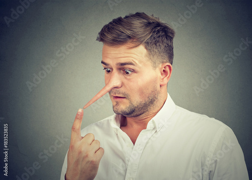 Canvas Print Worried shocked young man with long nose. Liar concept.