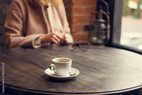 woman with white coffee cup on a table
