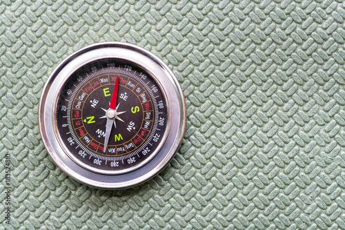 Compass lie on a green tourist rug.