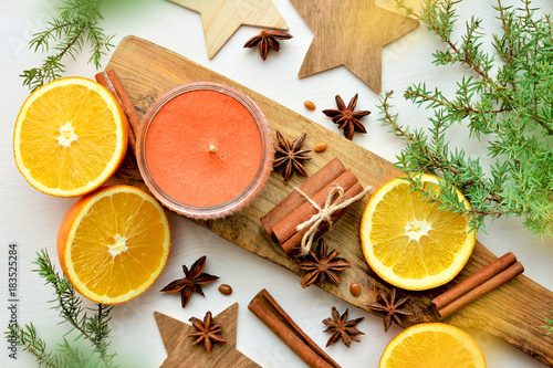 oranges with anisestars, cinnamon sticks, juniper branch and candle