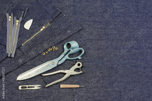 jeans textile background with scissors, zipper, chalk, pins