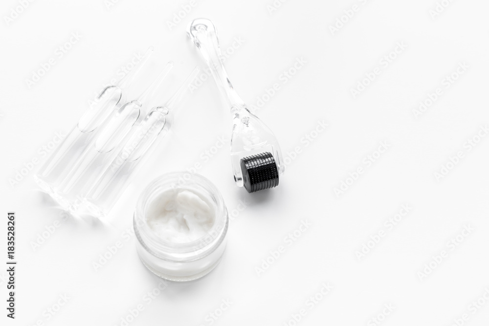 Desk of cosmetoligist. Dermaroller, creams and mask, ampoulie on white background copyspace Desk of cosmetoligist. Dermaroller, creams and mask, ampoulie on white background copyspace