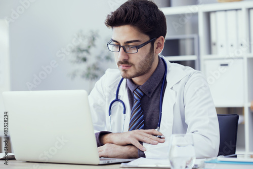 Portrait of doctor working on computer in medical office