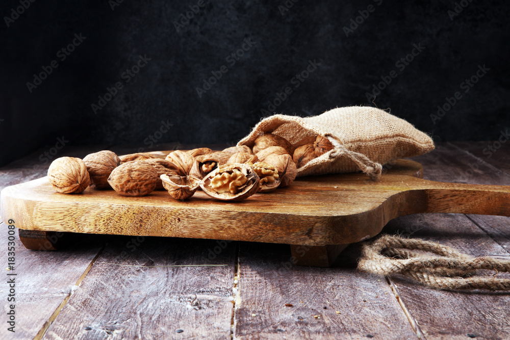 Fototapeta premium Walnut. Walnut kernels and whole walnuts in burlap sack.