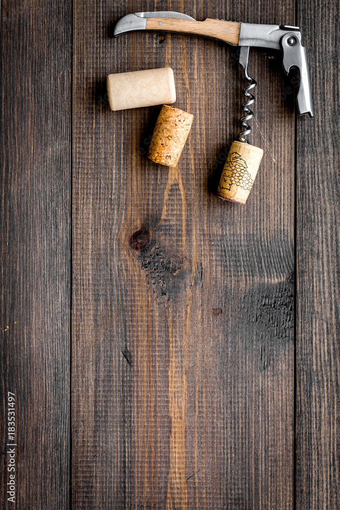 Open wine bottle. Corks and corkscrew on dark wooden background top view copyspace Open wine bottle. Corks and corkscrew on dark wooden background top view copyspace