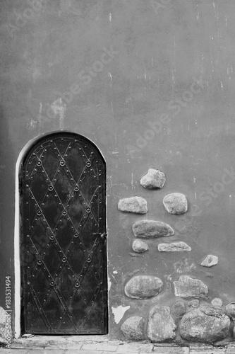 Black and White of Robust Door in Wall with Stones
