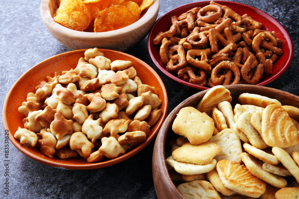 Salty snacks. Pretzels, chips, crackers in wooden bowls Salty snacks. Pretzels, chips, crackers in wooden bowls