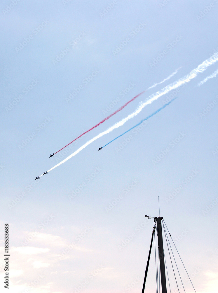 SAINT TROPEZ, PROVENCE, FRANCE - AUGUST 12TH 2014: Group of Jet Fighters Performing Acrobatic Tours During An Event Remembering 70 Years Since D-Day. Smoke Patterns Resemble the French Flag SAINT TROPEZ, PROVENCE, FRANCE - AUGUST 12TH 2014: Group of Jet Fighters Performing Acrobatic Tours During An Event Remembering 70 Years Since D-Day. Smoke Patterns Resemble the French Flag