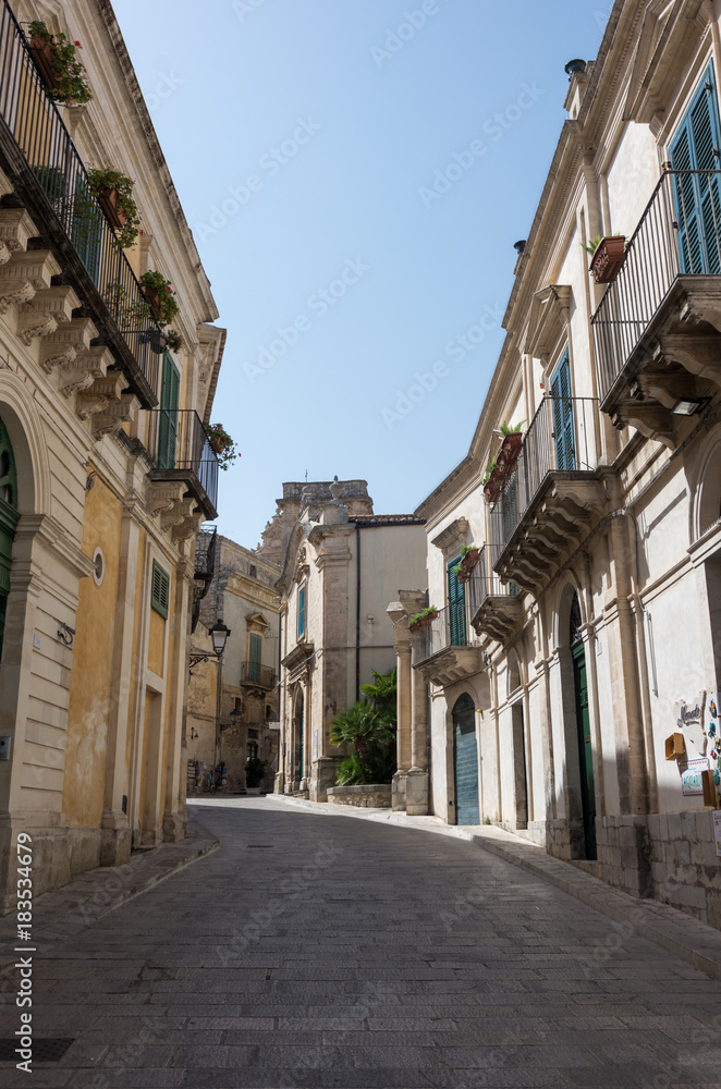 Narrow scenic street in Ragusa, Sicily, Italy with old townhouses