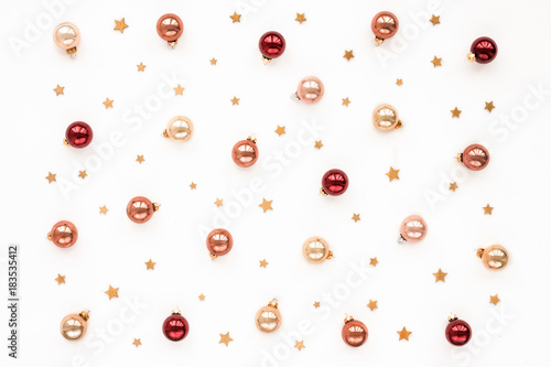 Christmas pastel, red, pearl bells, golden stars on white background, top view, flat lay