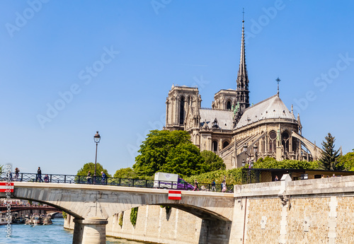 Notre Dame de Paris Catholic Christian Cathedral with the Seine river and the bridge Archbishopric on a sunny spring day. Paris