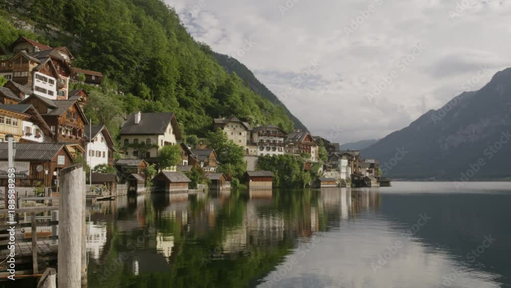Wide shot of reflection of mountain and houses in lake / Hallstatt, Austria Wide shot of reflection of mountain and houses in lake / Hallstatt, Austria