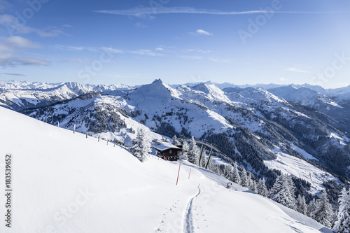 Skitour auf den Gipfel mit Spur und Lift im Hintergrund im Winter © christophstoeckl