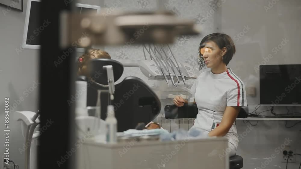 Children's dentist conducts a consultation with the little girl in my office. The doctor talks to a girl discussing future treatment. Children's dentist conducts a consultation with the little girl in my office. The doctor talks to a girl discussing future treatment.