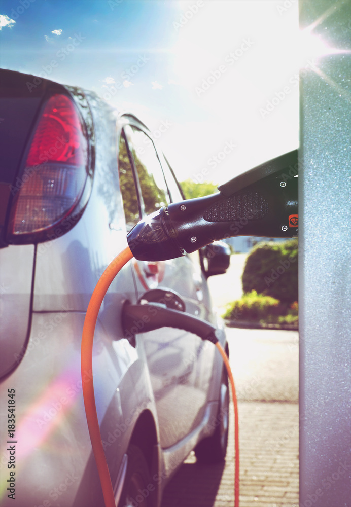 Obraz premium Elektroauto an Ladestation im Gegenlicht – Electric Car at Charging Station