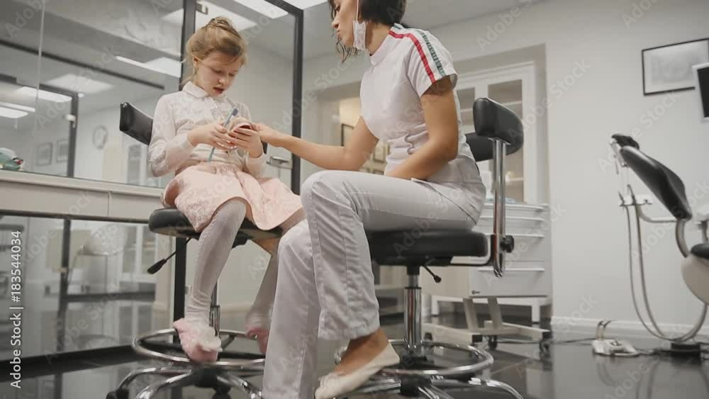 The dentist tells the girl how to brush teeth. Shows the layout as brushing correctly. Hitting the camera. Zoom camera. The dentist tells the girl how to brush teeth. Shows the layout as brushing correctly. Hitting the camera. Zoom camera.