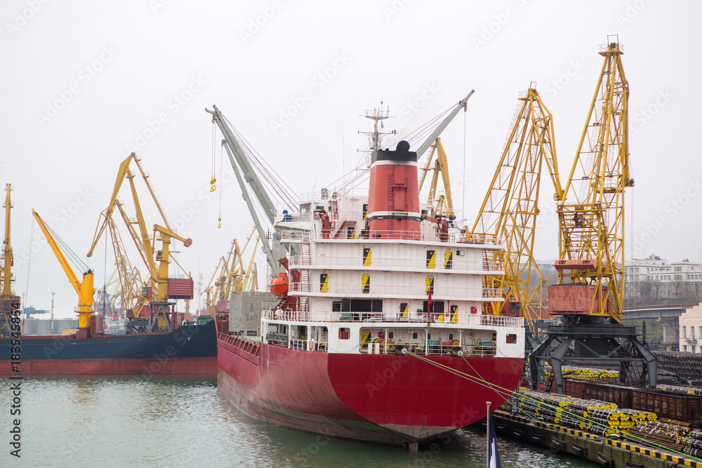 Vessel dry cargo on loading, unloading in port. Bulker in port. port terminal. Vessel Balker on loading pipes. Many pipes in port terminal