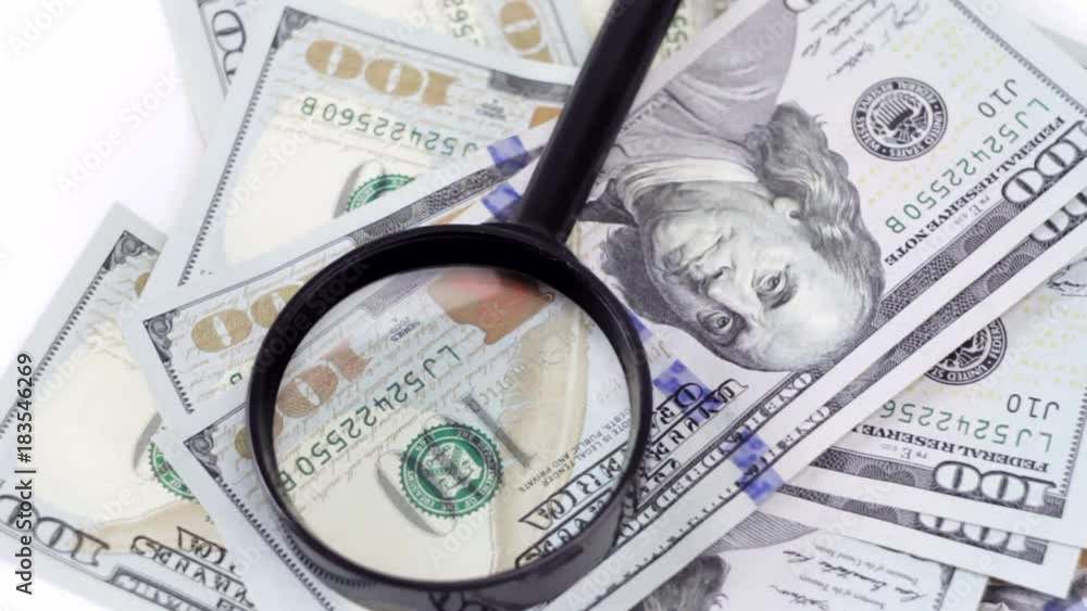 Cash one hundred dollars spinning with a magnifying glass Cash one hundred dollars spinning with a magnifying glass