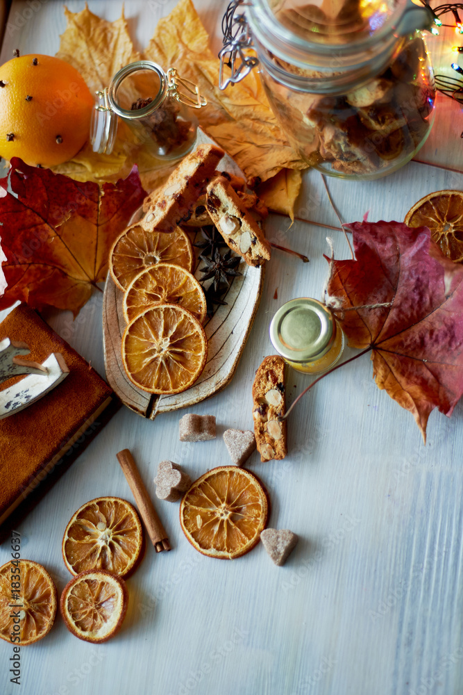 Cookies, biscotti, slices of orange, autumn leaves and a jar of jam or . The atmosphere of warmth and coziness. Cookies, biscotti, slices of orange, autumn leaves and a jar of jam or . The atmosphere of warmth and coziness.