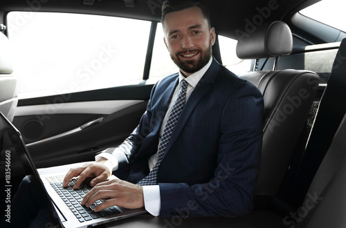 Businessman working on laptop keyboard sitting in car © ASDF