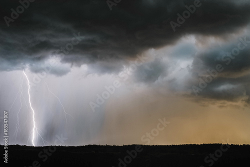 Scenic view of thunderstorm lightning over landscape photo