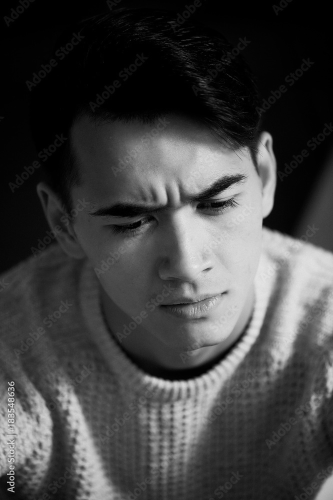 A young man with dark hair and eyes frowns. Reverie A young man with dark hair and eyes frowns. Reverie